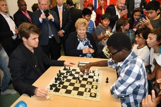 Student Marcus Sutton (right) squares off against World Chess Champion Magnus Ca
