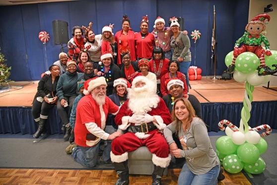 Volunteers join the Santas for a Christmas portrait.