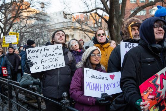 Sam Multer, a teacher at PS 282 in Park Slope, Brooklyn, and Leni Abraham, a physical  therapist who serves multiple schools, carry signs in solidarity with Minneapolis.