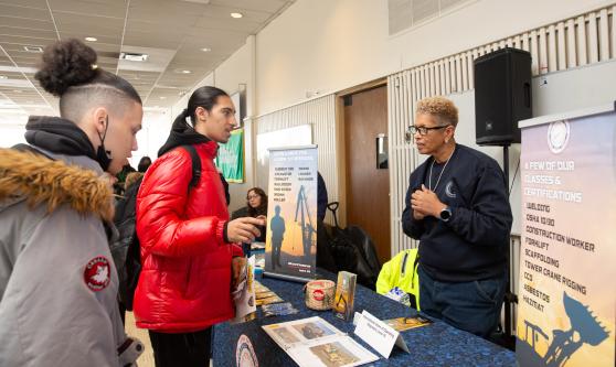 Students from Gotham HS in Manhattan explore engineering careers at the International Union of Operating Engineers' table during the UFT's Future in Focus fair. 