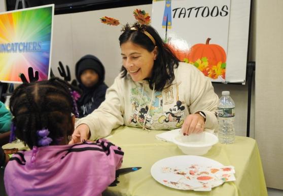 A teacher assists a student at the 2024 UFT Middle School Division’s annual Thanksgiving Luncheon on Nov. 23, 2024 at UFT headquarters. 