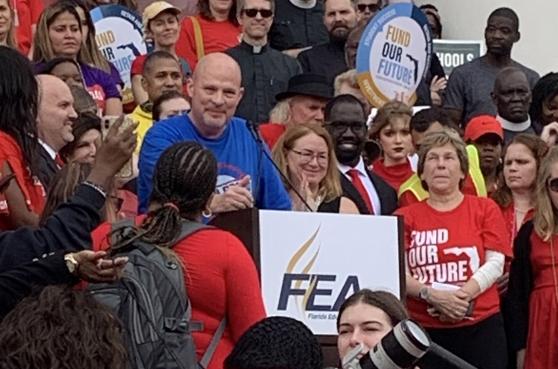 Mulgrew stands among a crowd of women wearing red shirts