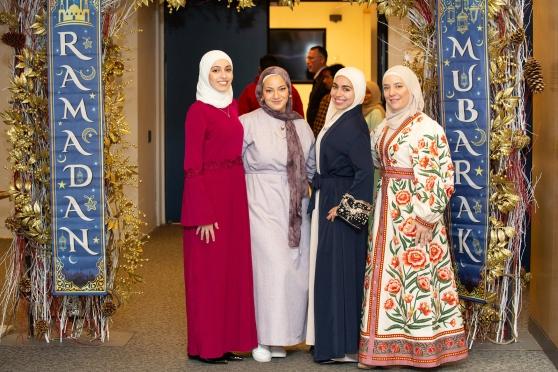 Teachers attending the UFT Muslim Educators Committee Iftar Dinner on March 7, 2025 pose between banners reading “Ramadan Mubarak,” which means “Blessed Ramadan.”