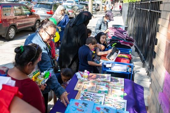 Families choose from a selection of children’s books and school supplies.