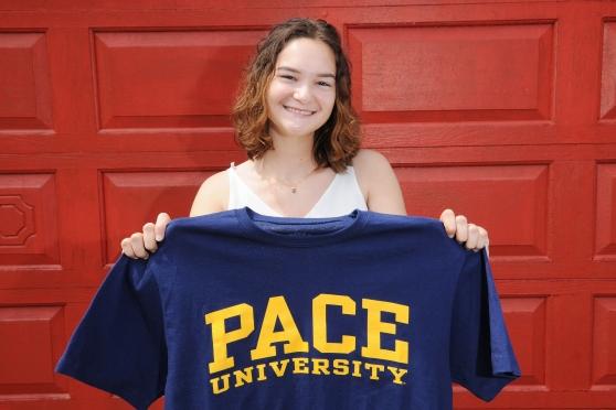 Teenager holding up Pace University T-shirt