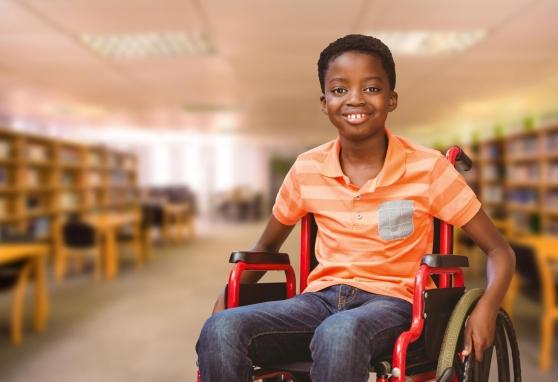 Young boy in a wheelchair in a library