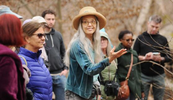 A woman with a hat on looks back towards a group she is leading 