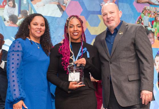 Kendra Edwards (center), a paraprofessional honoree from PS 23 in the Bronx, is congratulated by UFT Paraprofessionals Chapter Chair Priscilla Castro and UFT President Michael Mulgrew at the 2025 UFT Paraprofessionals Awards Luncheon on March 22, 2025. 