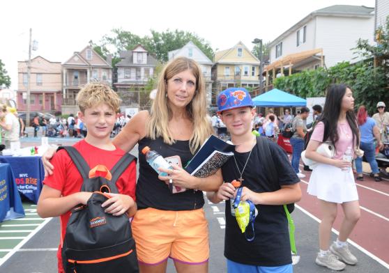 A Staten Island parent smiles for a photo with her two children at the UFT's 5th annual Staten Island Back-to-School BBQ.