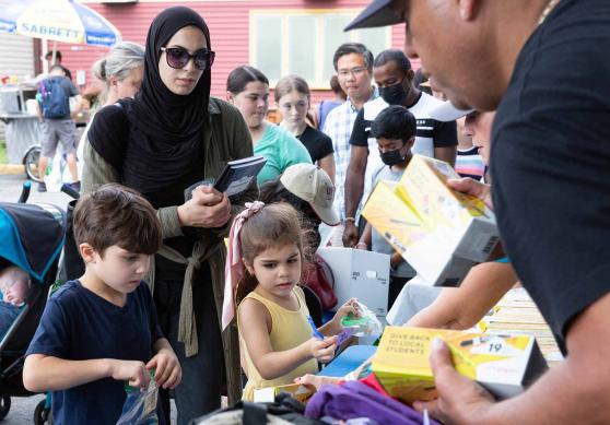 A woman with two kids select books