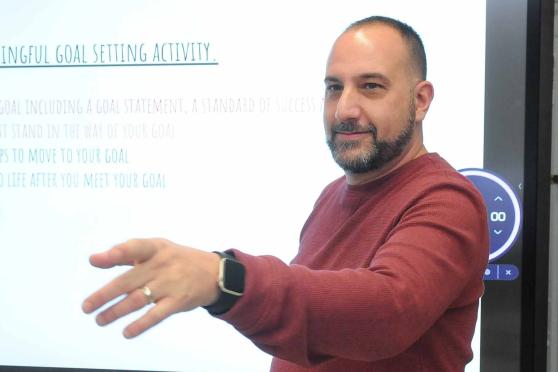 Teacher in front of a slide projection