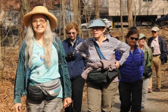 A woman leading a group through the park 