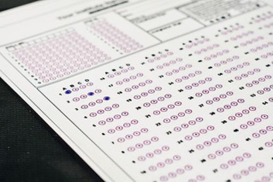 Photo of a standardized bubble test with person filling in circles with a blue pen