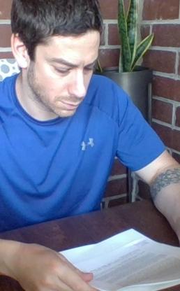 Man sits at table looking at paper work