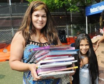 Samantha Persaud carries an armful of books for her daughter, who attends PS 123
