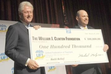 Former President Bill Clinton accepts the check donated to his foundation for Ha