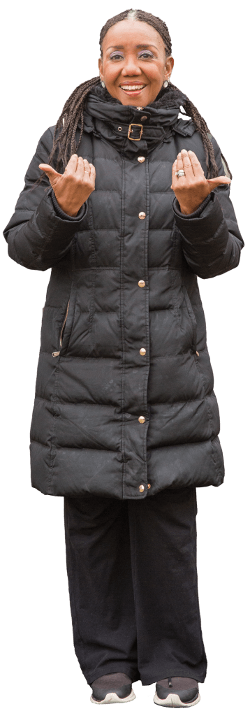 Woman with a winter coat on performing American sign language