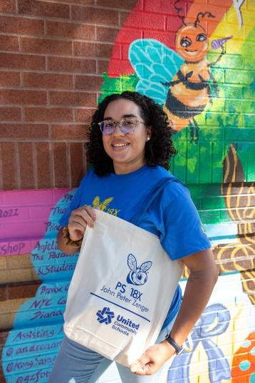  Community School Director Jubetsy Minaya with one of the gift bags full of PS 18 swag that the school distributed to families.•