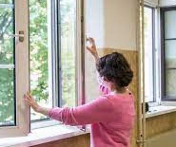 A teacher opening a window