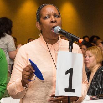 Renee Freeman,  a paraprofessional at the Academy of Medical Tech-nology in Far Rockaway, Queens, asks  the panel a question.